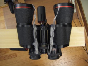Loop the fasteners around the middle of the binocs, and under the bottom of the support